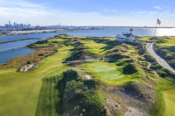 a view of the 18th hole at governors island with the city of ny in the  at Harbor Pointe, Bayonne